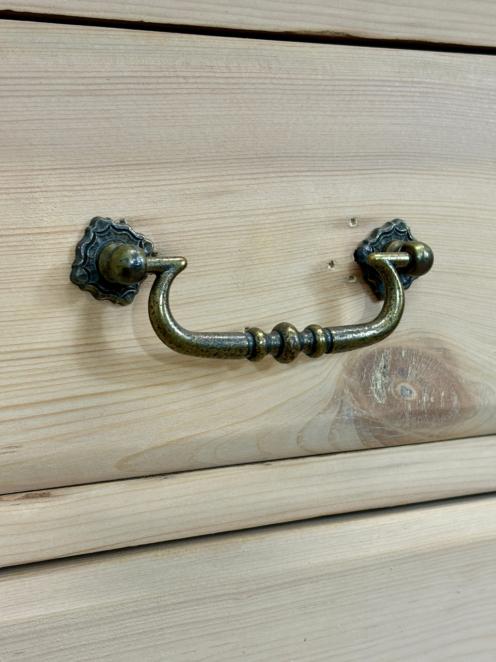 Brass cabinet handle on a wooden drawer