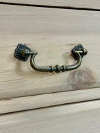Brass cabinet handle on a wooden drawer