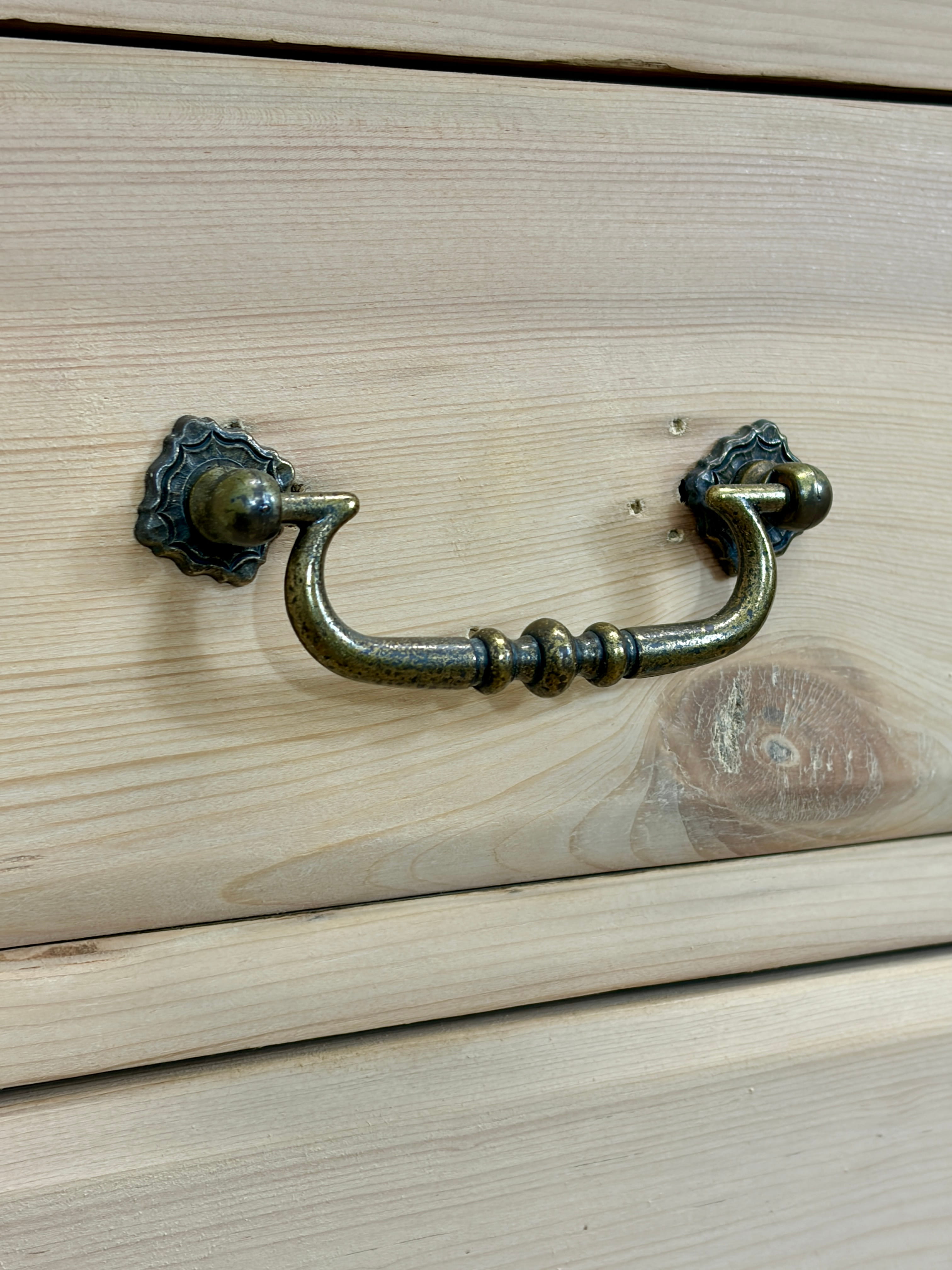 Brass cabinet handle on a wooden drawer