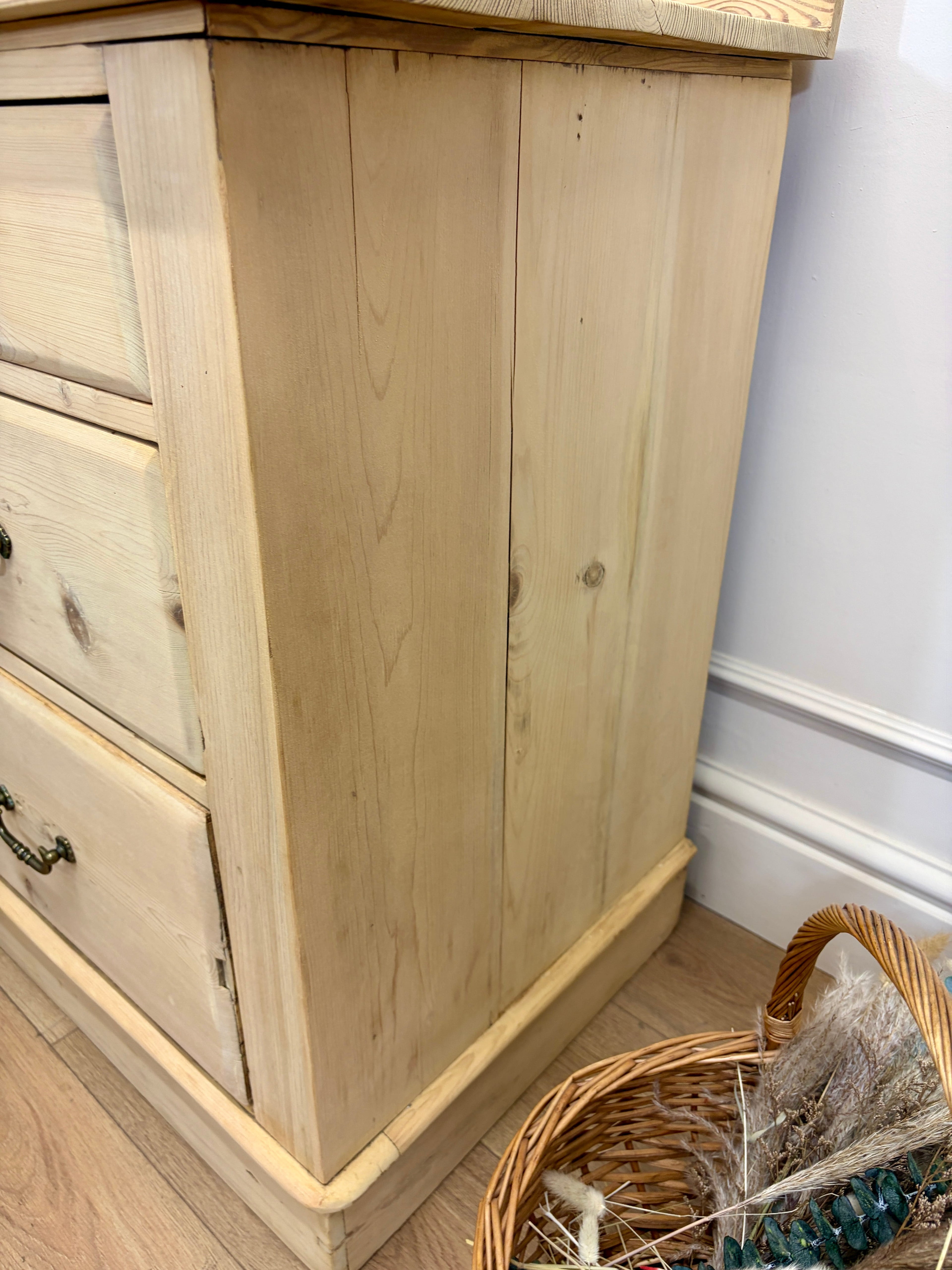 Wooden dresser with a wicker basket on a wooden floor.