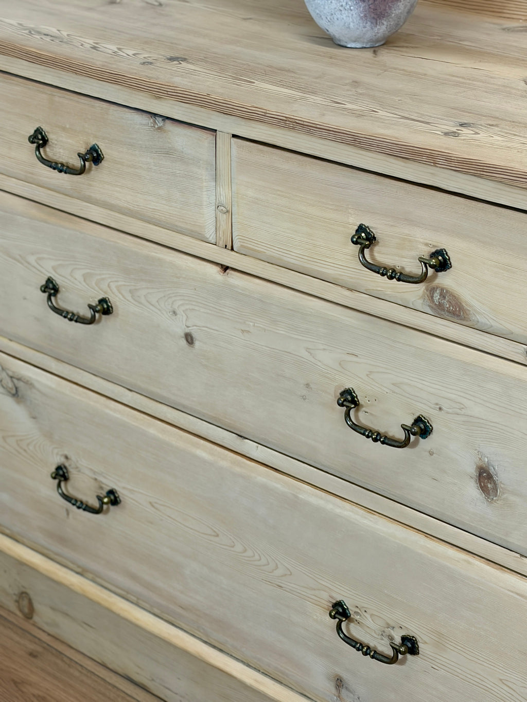 Wooden dresser with metal handles on a wooden surface