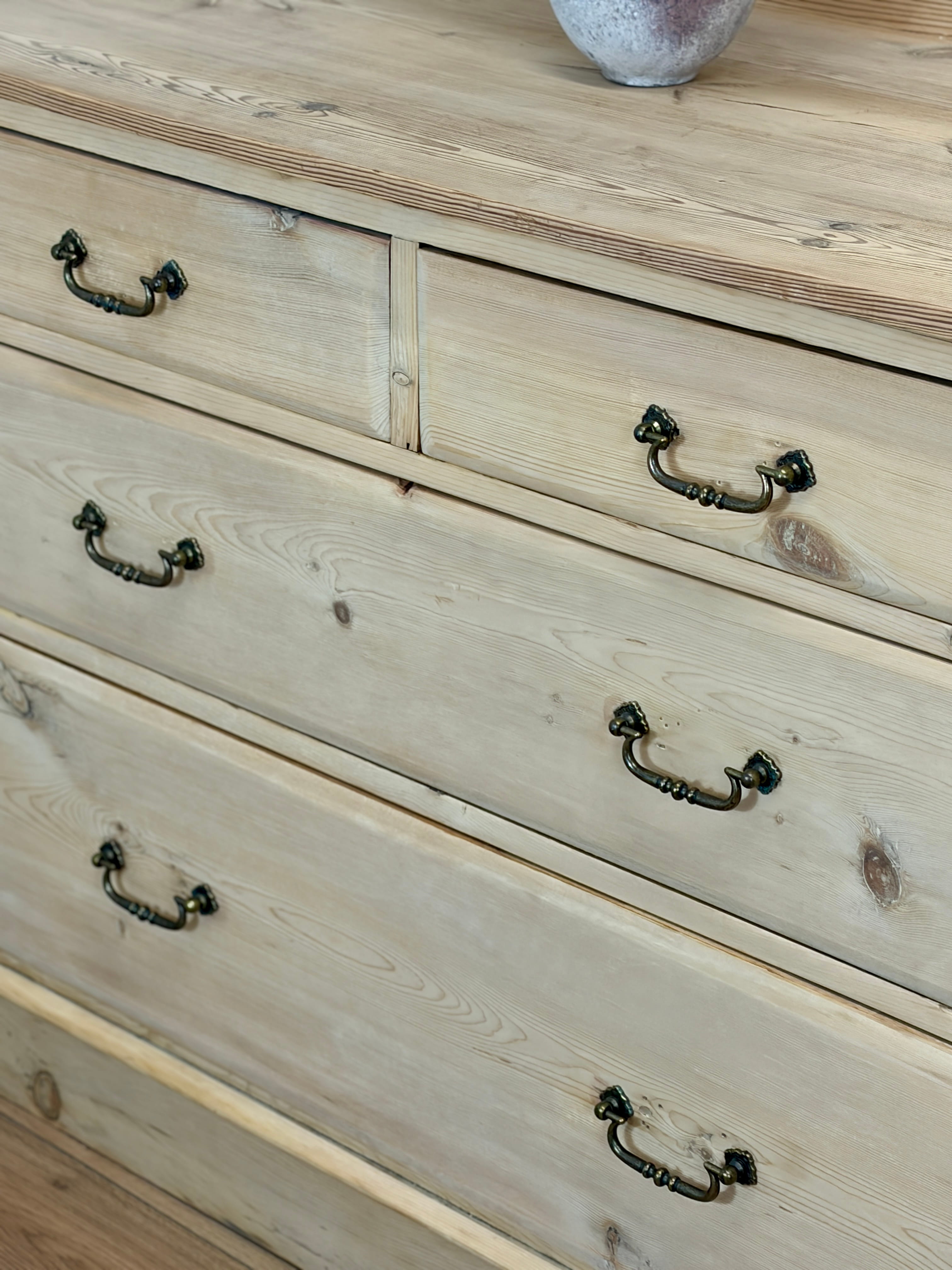 Wooden dresser with metal handles on a wooden surface