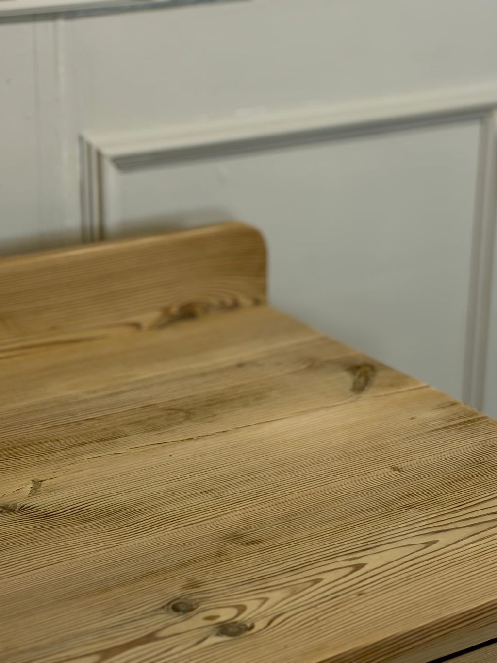 Wooden countertop with a white wall in the background