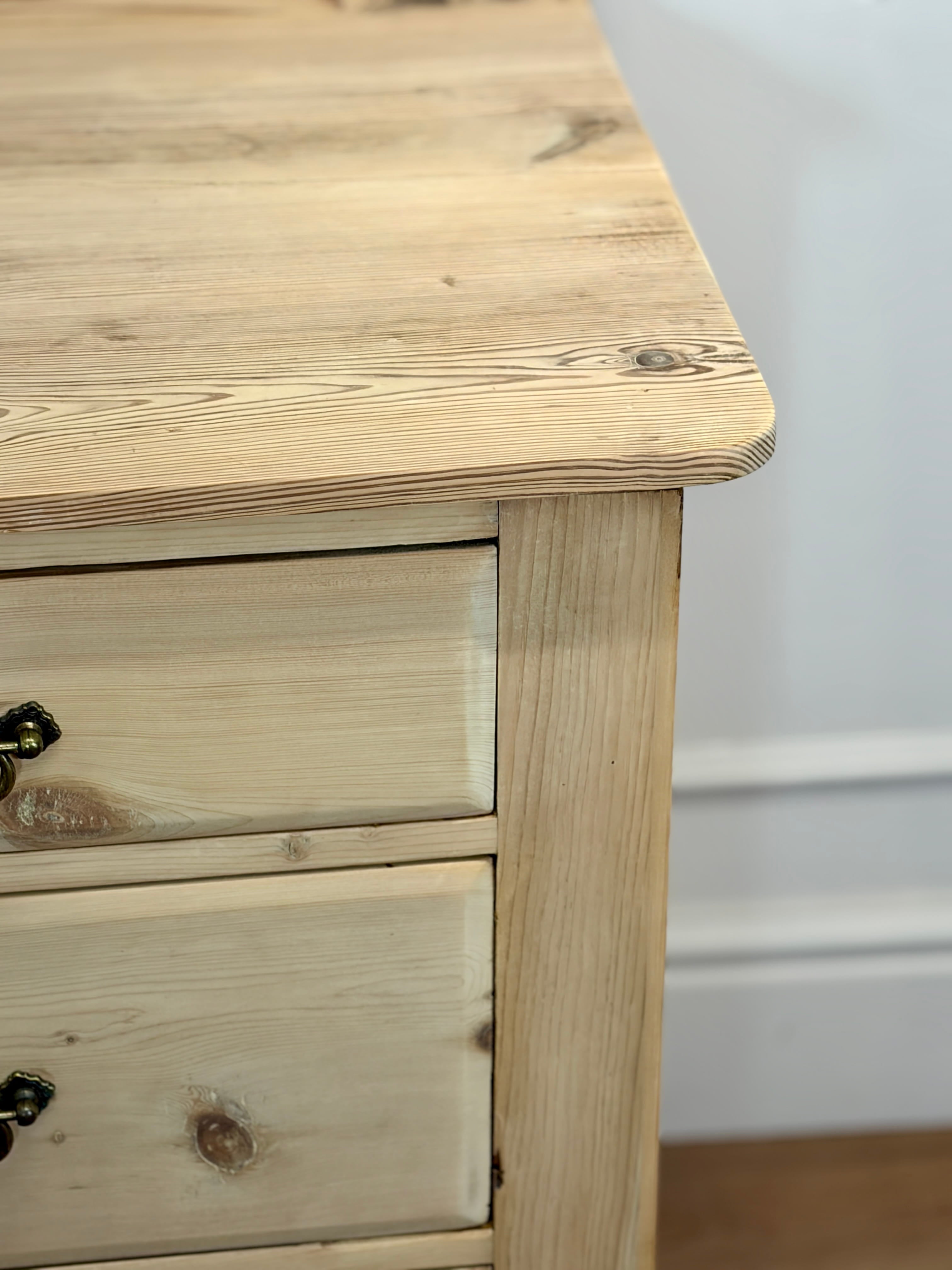 Wooden dresser with two drawers against a white wall.