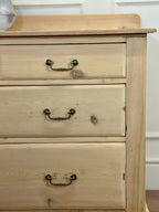 Wooden dresser with three drawers and metal handles on a white background