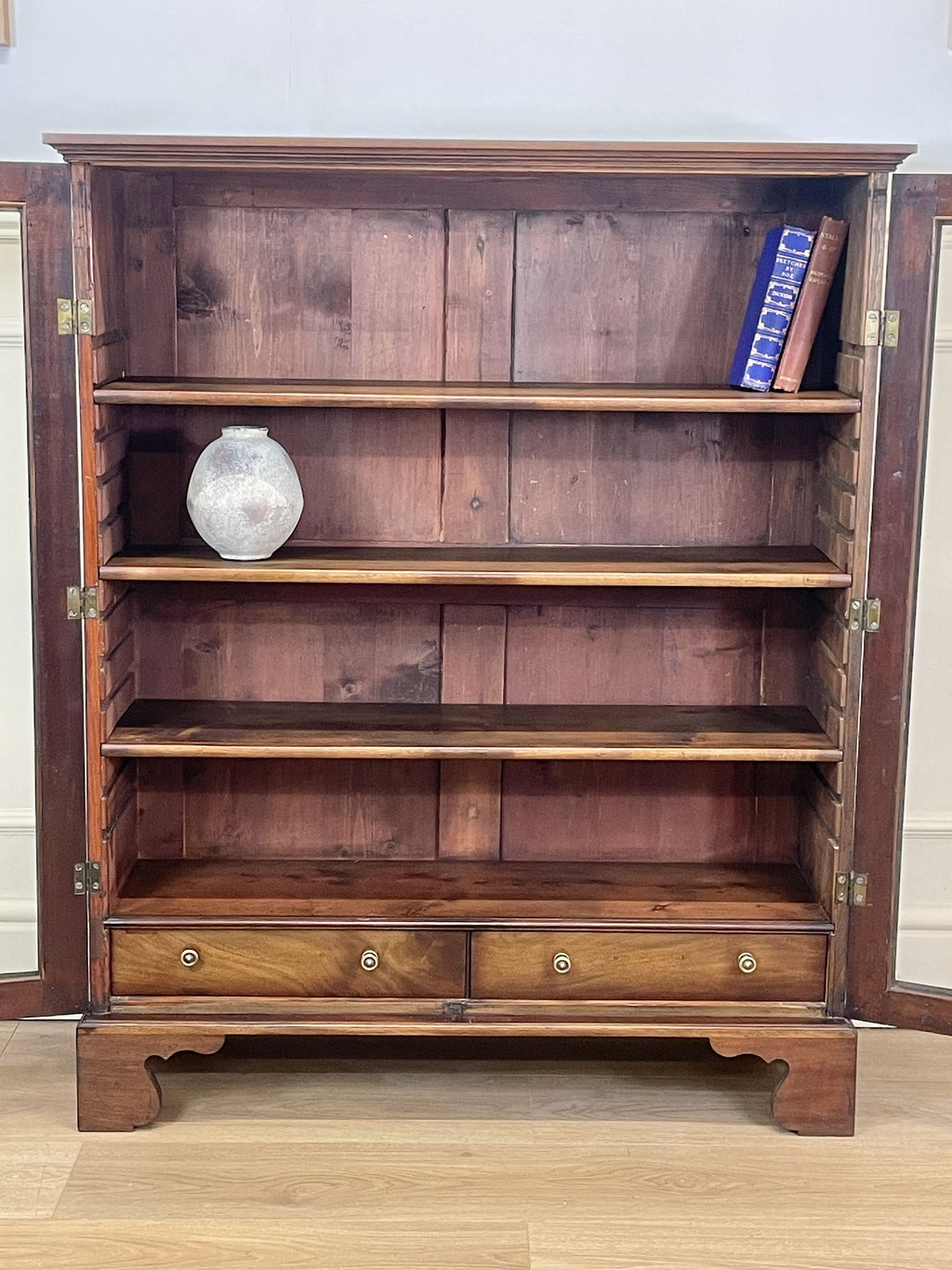Wooden bookshelf with decorative items on a wooden floor