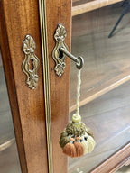 Decorative door handle with tassels on a wooden door