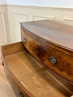 Wooden curved desk with a smooth finish in a room with white paneled walls.