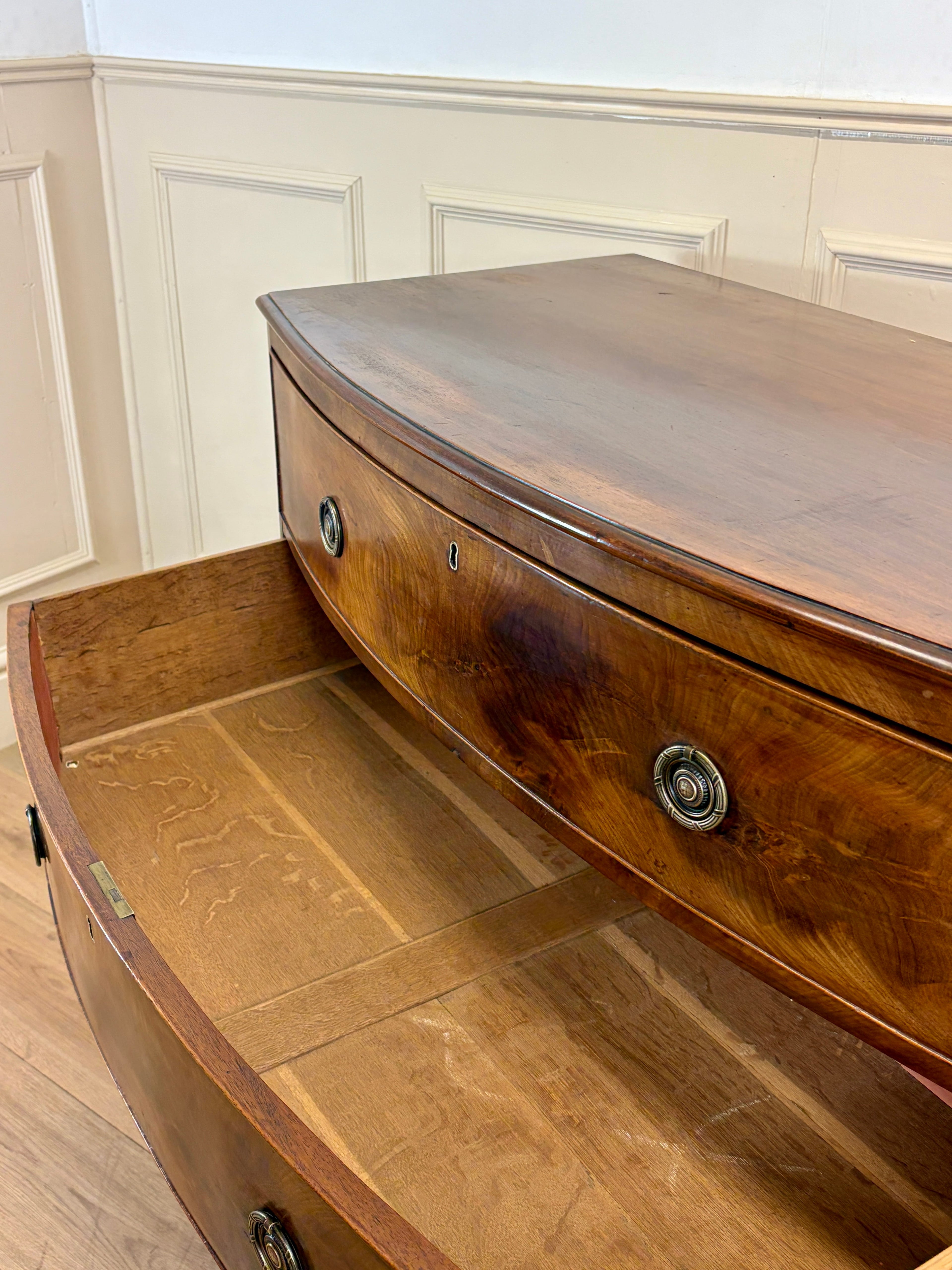 Wooden curved desk with a smooth finish in a room with white paneled walls.