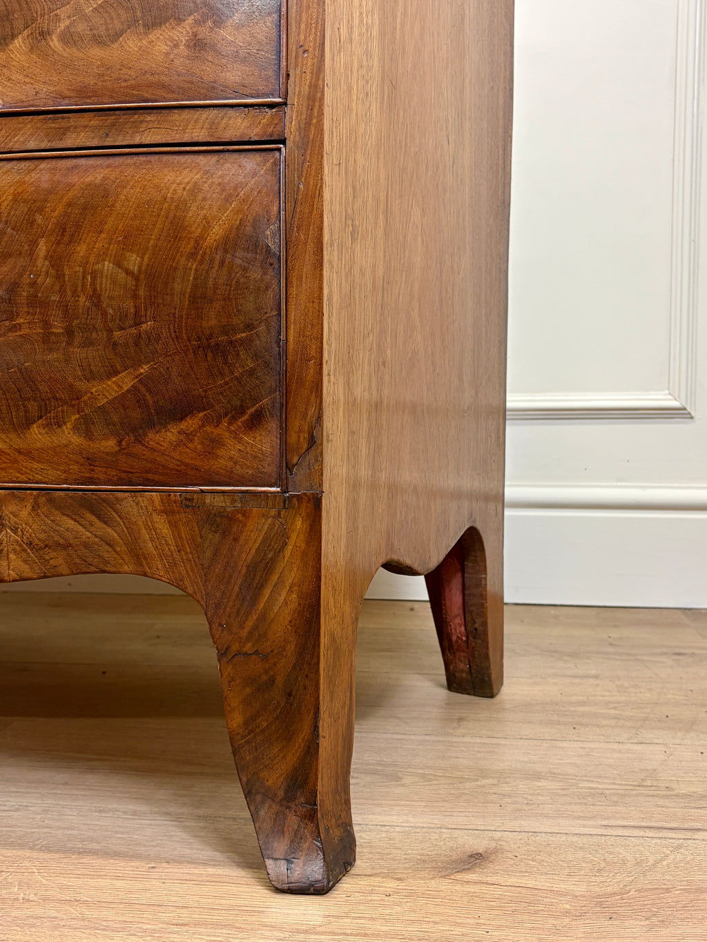 Close-up of a wooden cabinet with a white panel background