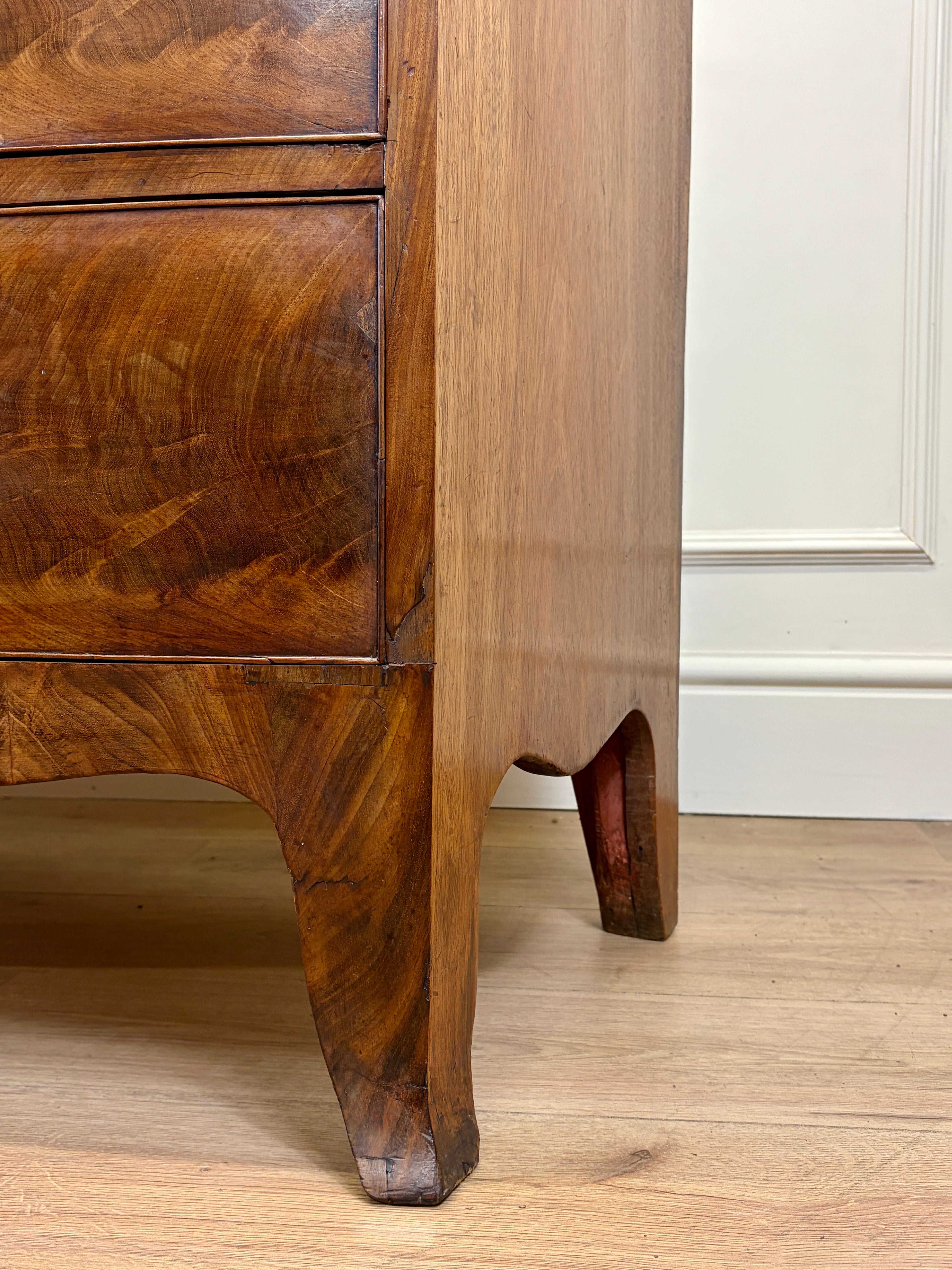 Close-up of a wooden cabinet with a white panel background