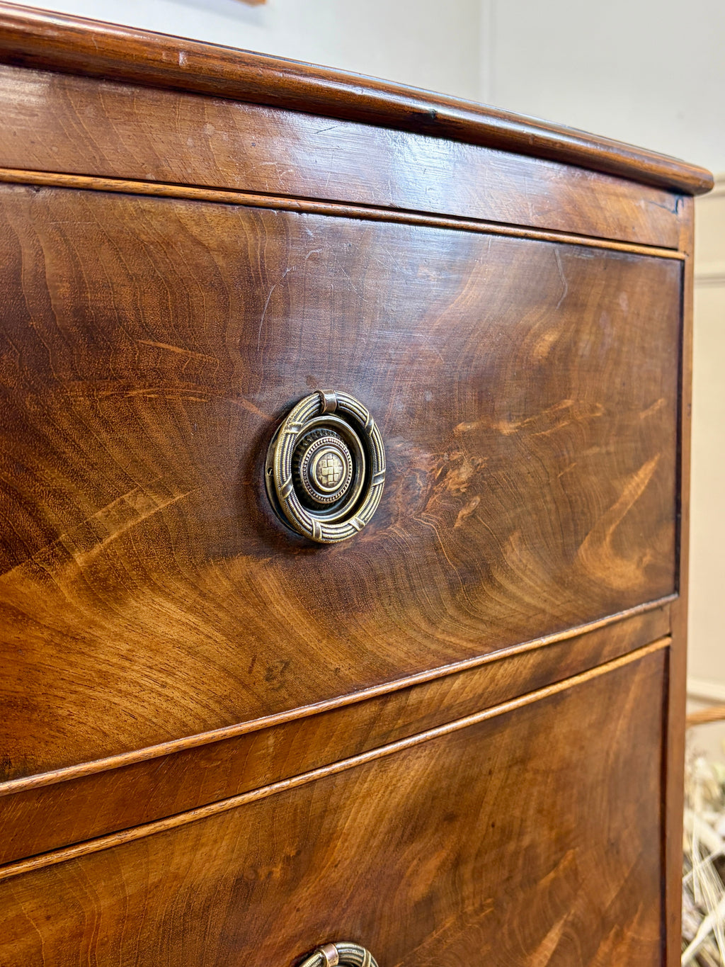 Close-up of a wooden drawer with a brass handle