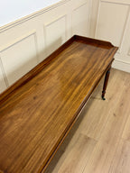 Wooden tray on a light wooden floor with white paneled walls.