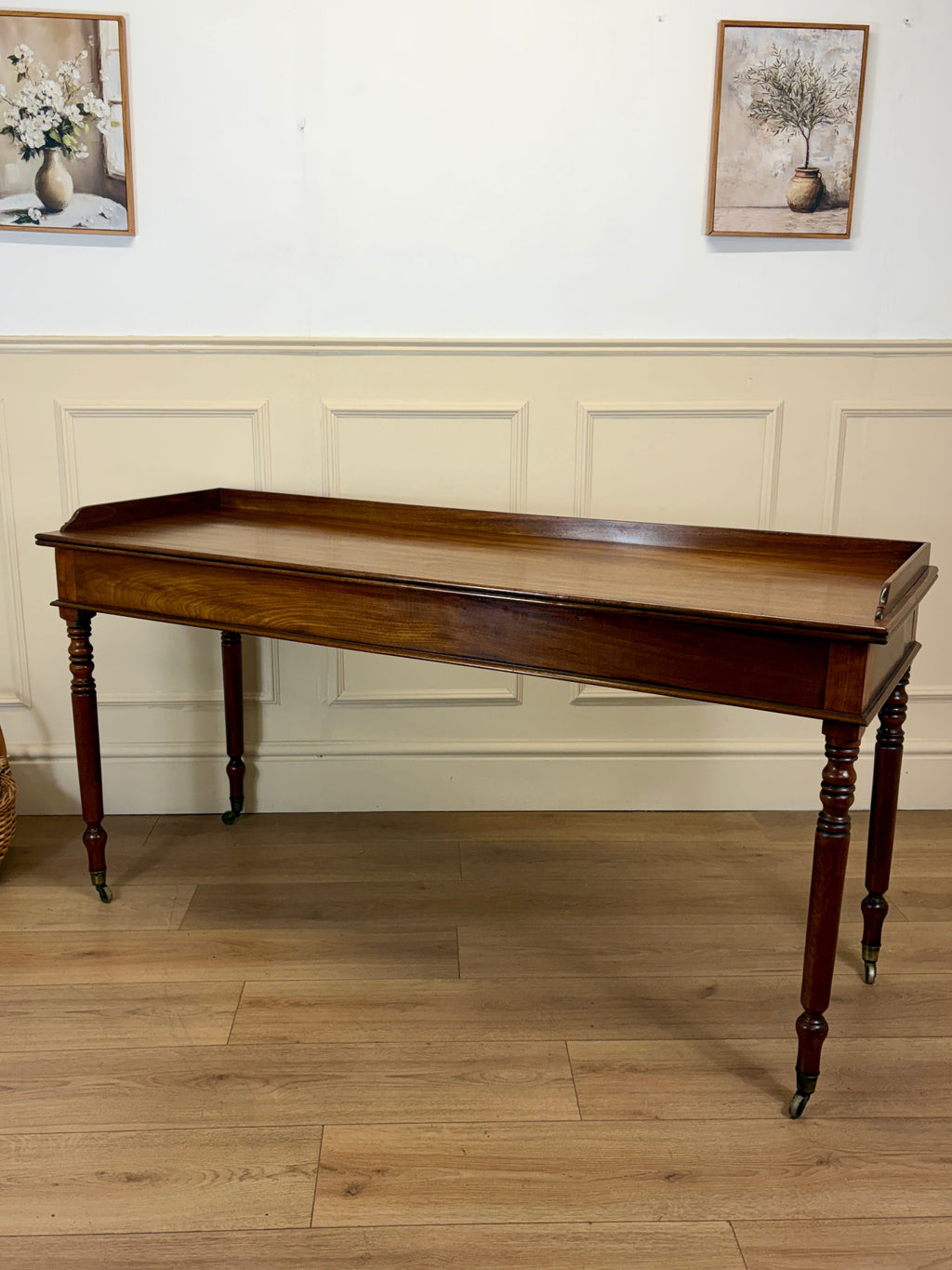 Wooden console table in a room with light-colored walls and wooden floor.