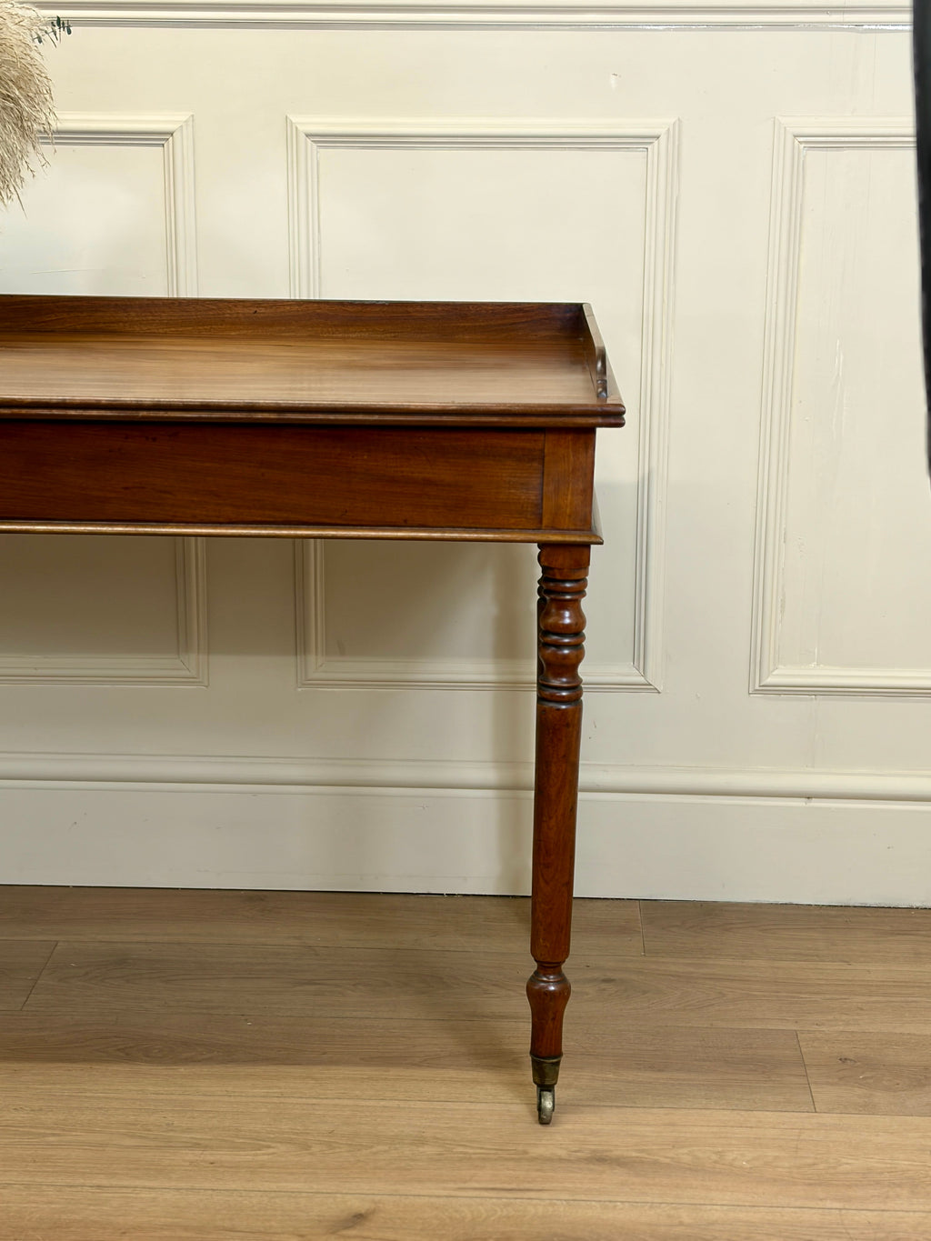 Wooden desk against a white paneled wall