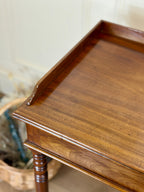 Wooden side table with a wicker basket in the background