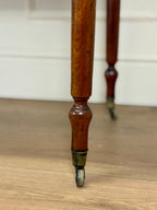 Close-up of a wooden leg with a metal foot on a wooden floor.
