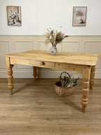 Wooden table with decorative items on a wooden floor, framed by wall art.
