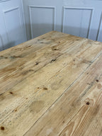 Wooden table with a rustic finish against a light blue paneled wall.