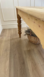 Wooden table with a woven basket on a wooden floor.