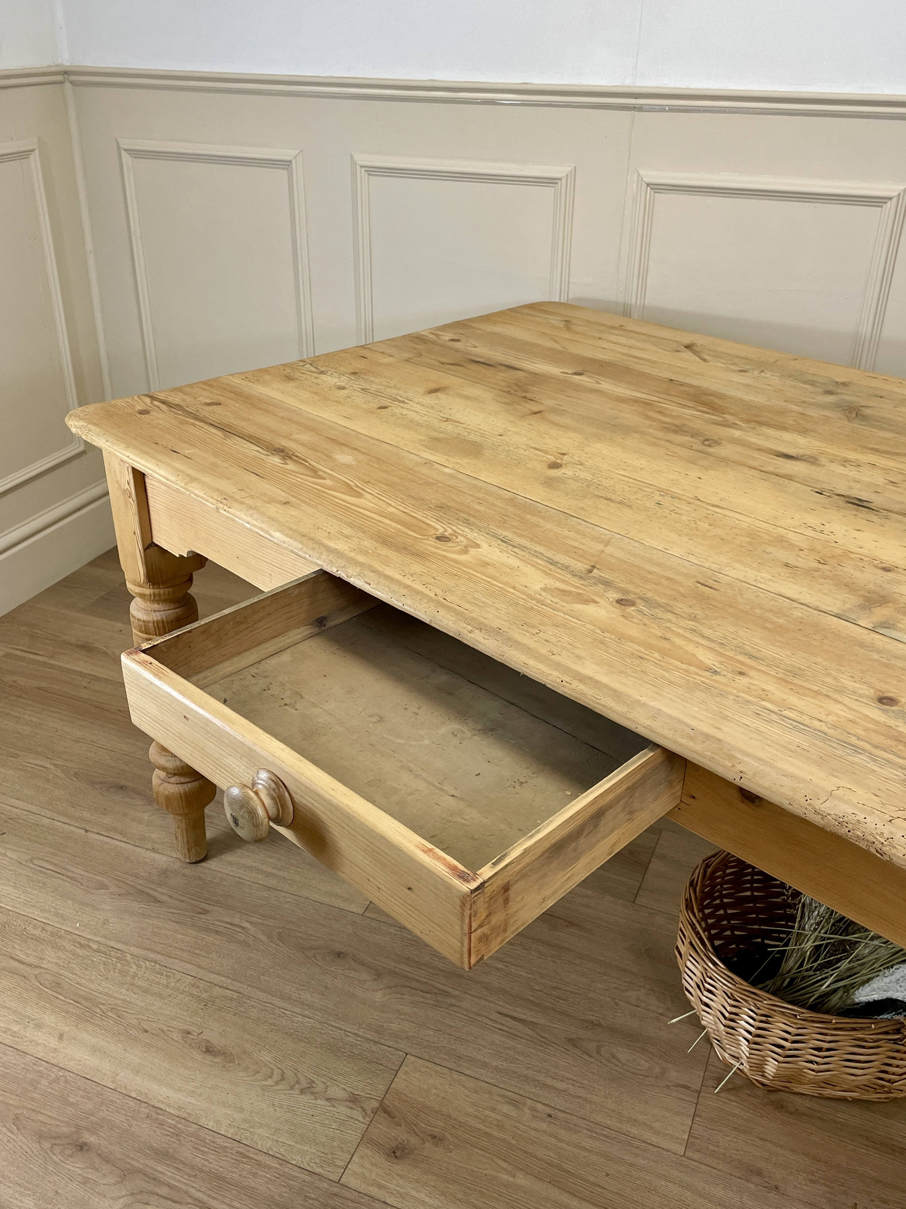 Wooden coffee table with a drawer in a room with wainscoting.