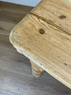 Close-up of a wooden table corner with visible grain and texture.