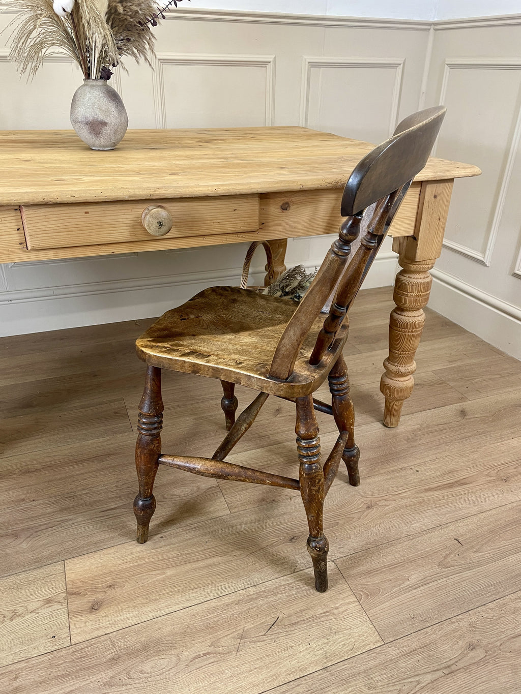 Wooden table with a chair in a room with panelled walls.