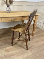 Wooden table with a chair in a room with panelled walls.