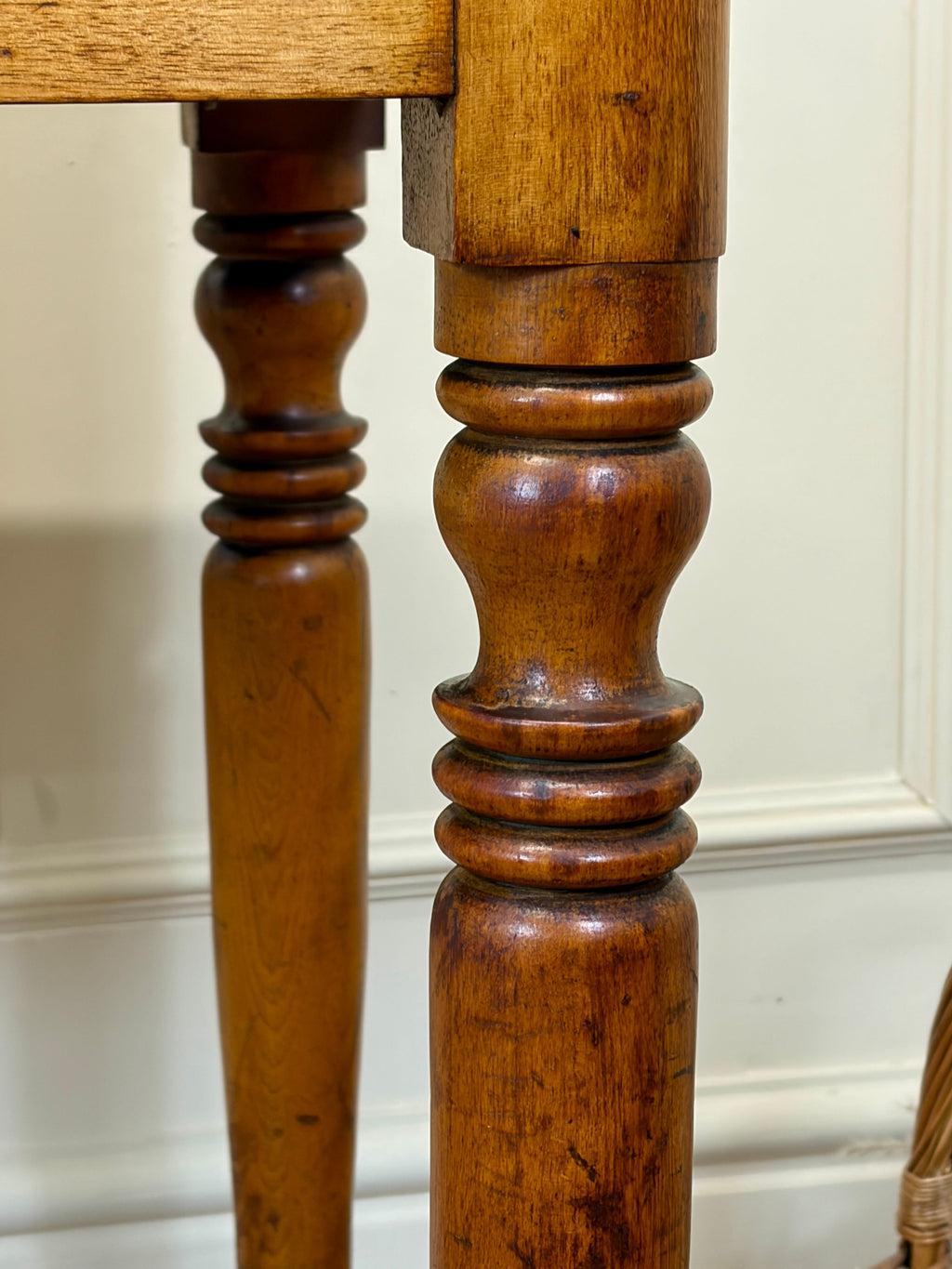 Close-up of wooden legs with a white wall background