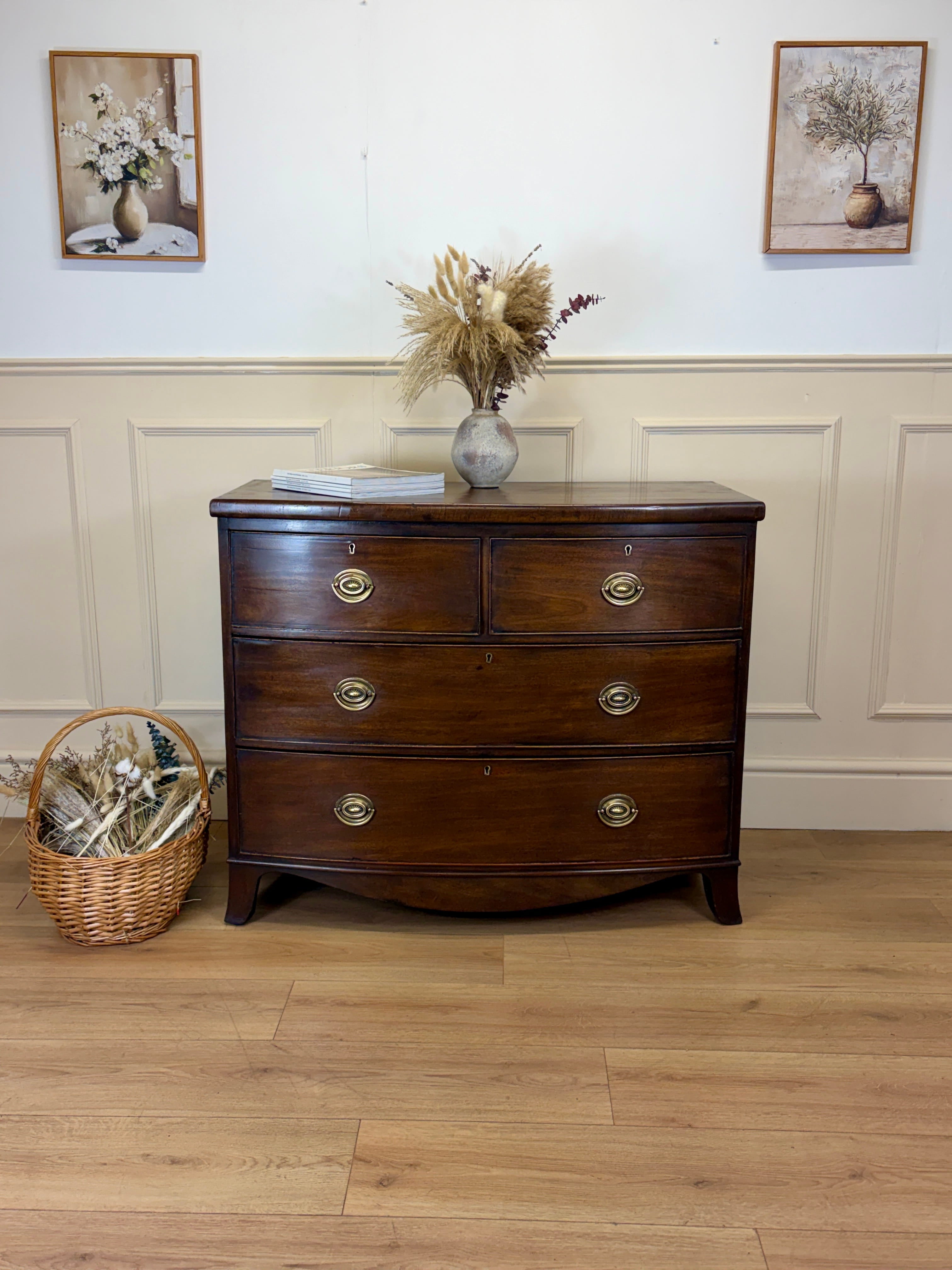 Wooden dresser with decorative items on a wooden floor and white wall background