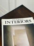 Magazine titled 'The World of Interiors' on a wooden surface.