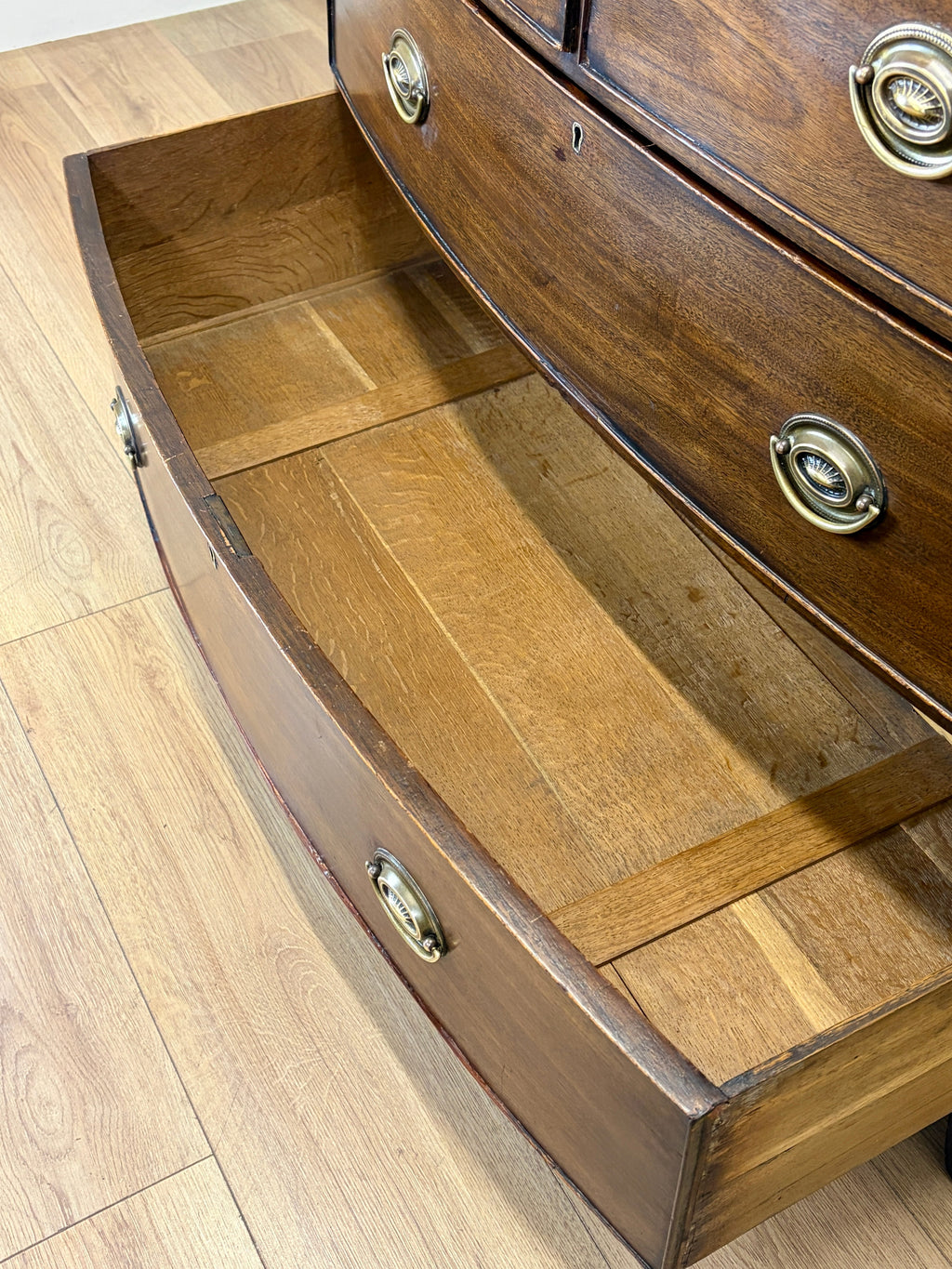 Wooden drawer with brass handles on a wooden floor