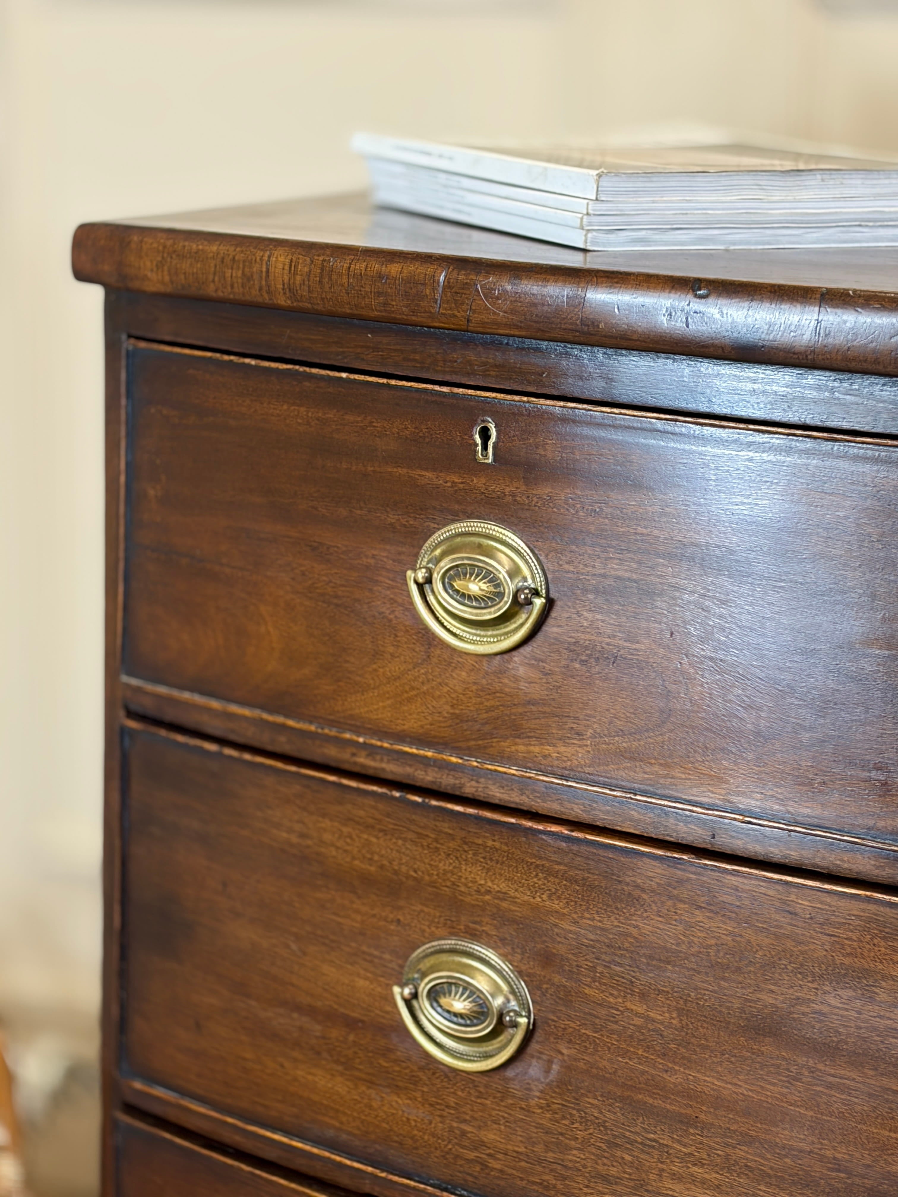 Wooden dresser with brass handles on a neutral background