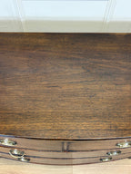 Wooden surface with a curved edge and metallic handles.