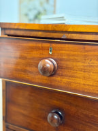 Close-up of a wooden drawer with a knob and lock mechanism.