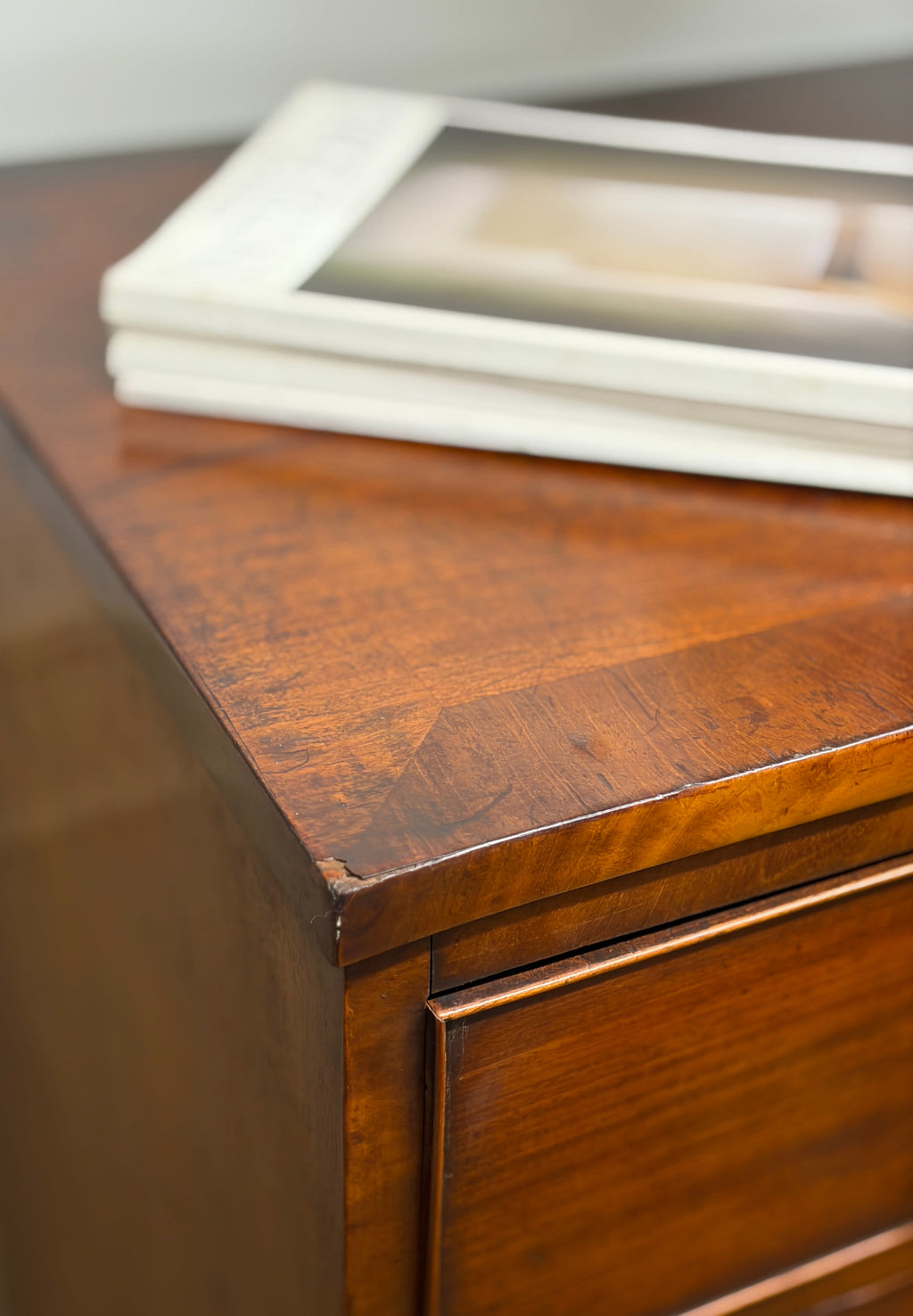 Wooden dresser with a stack of white papers on top