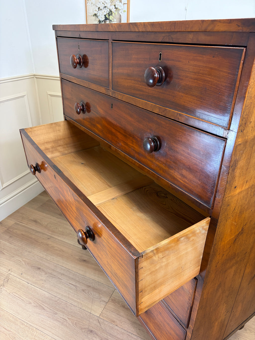 Wooden dresser with open drawer in a room setting