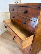 Wooden dresser with open drawer in a room setting