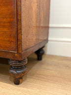 Close-up of a wooden cabinet leg on a wooden floor