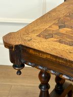 Close-up of a wooden table with intricate inlay work on a light-colored floor.