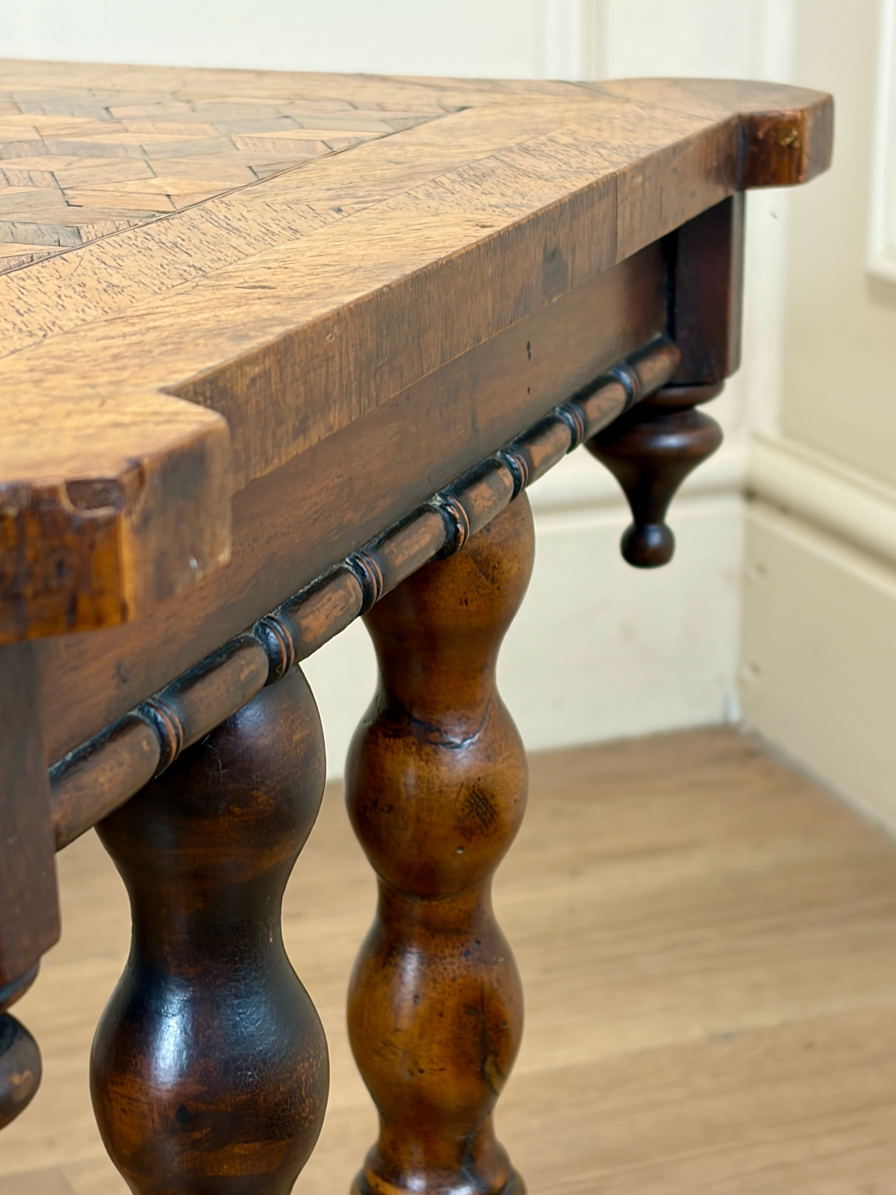 Close-up of a wooden table with turned legs in a room setting.
