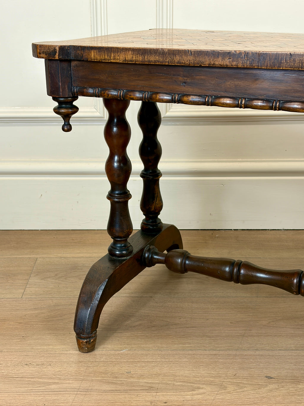 Wooden table with a rustic design on a wooden floor.