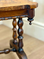 Close-up of a wooden table with intricate leg design on a neutral background