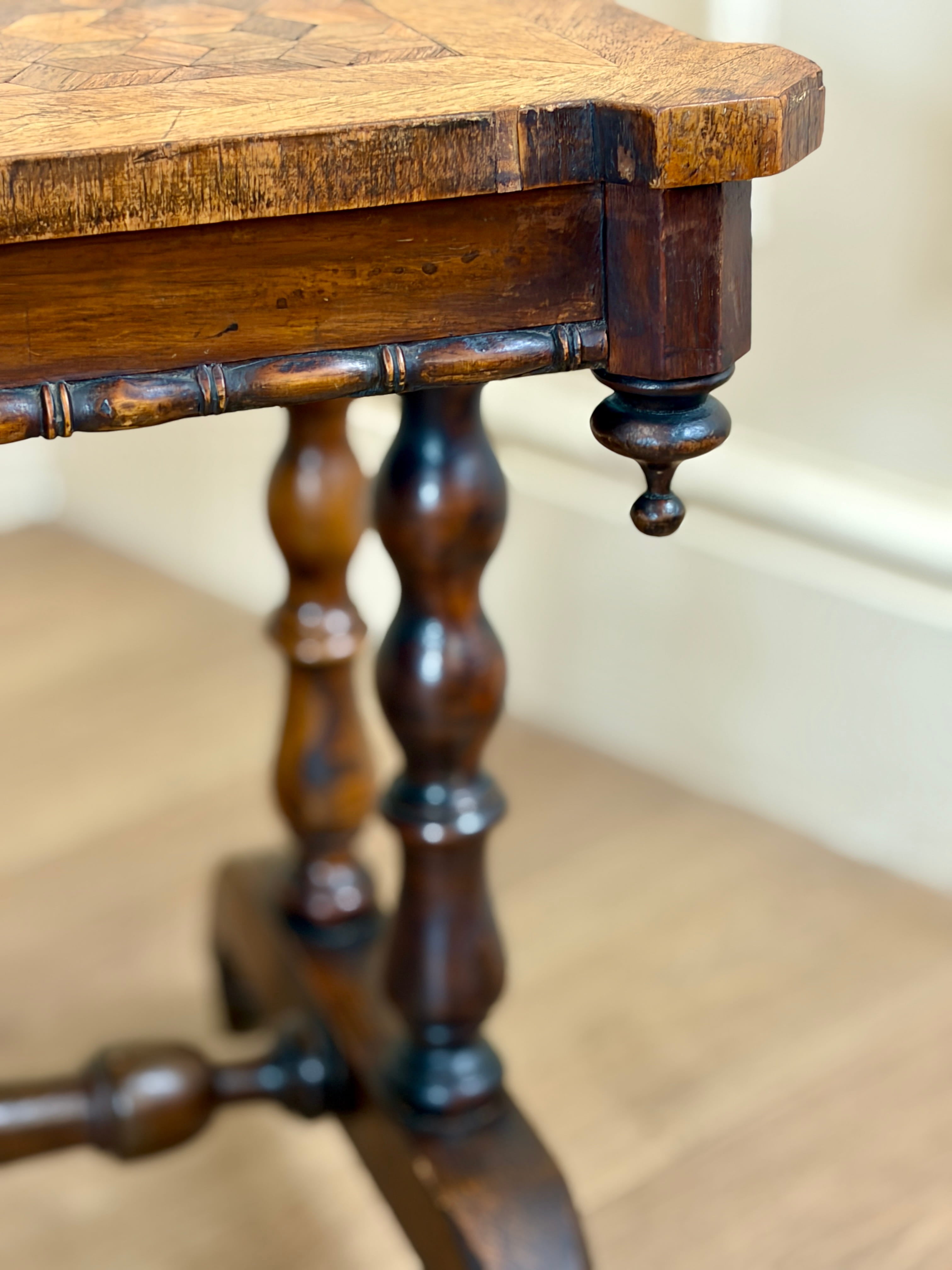 Close-up of a wooden table with intricate leg design on a neutral background