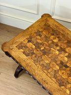 Wooden ottoman with a geometric pattern on a wooden floor.