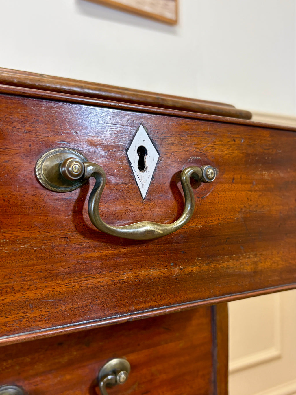 Close-up of a wooden drawer with brass handle and keyhole.