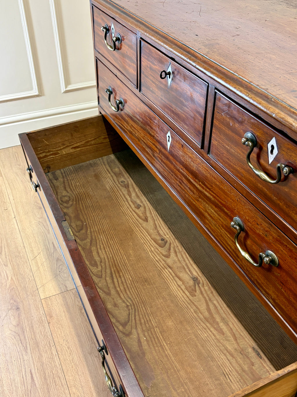 Wooden dresser with open drawer on a wooden floor