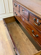 Wooden dresser with open drawer on a wooden floor