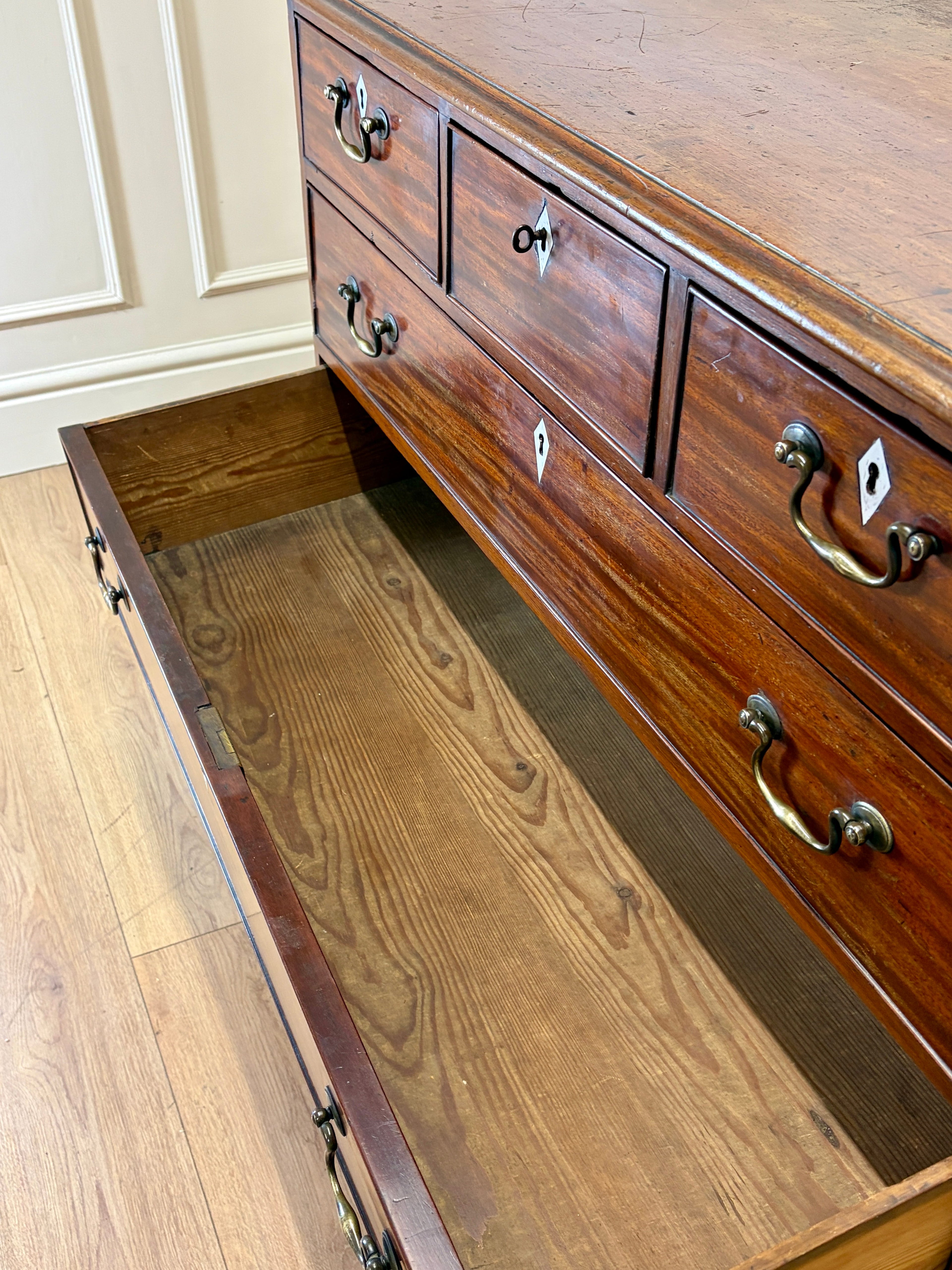 Wooden dresser with open drawer on a wooden floor