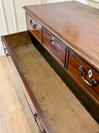 Wooden dresser with open drawer on a wooden floor